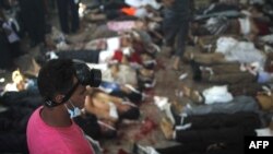 A man looks at bodies laid out in a make shift morgue after Egyptian security forces stormed two huge protest camps at the Rabaa al-Adawiya and Al-Nahda squares where supporters of ousted president Mohamed Morsi were camped, in Cairo, on August 14, 2013.
