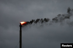 Clouds from Hurricane Harvey are seen in the background as smoke rises from a burn off at an oil refinery in Corpus Christi, Texas, August 26, 2017.