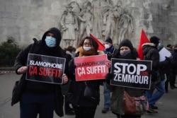 FILE - Activists hold placards reading 'Islamophobia is enough' and 'Stop Zemmour', Feb. 14, 2021, in Paris.
