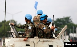 FILE - Peacekeepers serving in the United Nations Organization Stabilization Mission in the Democratic Republic of the Congo (MONUSCO) patrol in their armoured personnel carrier during demonstrations against Congolese President Joseph Kabila in the street