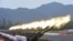 FILE - Paramilitary policemen and members of a gun salute team fire cannons during a training session for a military parade to mark the 70th anniversary of the end of the World War II, at a military base in Beijing, China. China is now the world’s third largest arms exporter behind the U.S. and Russia, and the country accounted for nearly six percent of arms exports between 2011 and 2015.