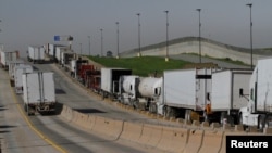 FILE - Trucks wait for border customs control to cross into the U.S. at the Otay border crossing in Tijuana, Mexico, Feb. 2, 2017.