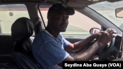 Modou Fall au volant de sa voiture, à Dakar, le 9 décembre 2019. (VOA/Seydina Aba Gueye)