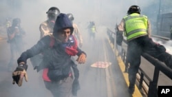 Un manifestante trata de huir de las fuerzas de seguridad durante una manifestación de la oposición al gobierno de Nicolás Maduro en Caracas, el 20 de mayo de 2017.