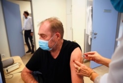 A man receives a Chinese made Sinopharm COVID-19 vaccine in Budapest, Hungary on Wednesday, Feb. 24, 2021. China is providing the vaccine to countries such as Serbia and Hungary -- a significant geopolitical victory in Central Europe and the Balkans, wher