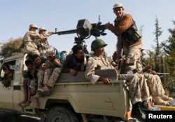 FILE - Houthi rebel fighters patrol a street in Sana'a, Yemen, Jan. 21, 2015.