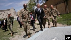 FILE - U.S. Defense Secretary James Mattis, third right, walks with U.S. Army Command Sergeant Major David Clark, left, and General Christopher Haas, second right, as he arrives to the Resolute Support headquarters in Kabul, Afghanistan, April 24, 2017.