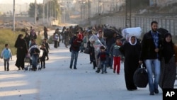 This Nov. 27, 2016, photo provided by the Rumaf, a Syrian Kurdish activist group, shows people fleeing rebel-held eastern neighborhoods of Aleppo into the Sheikh Maqsoud area that is controlled by Kurdish fighters.