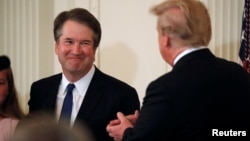 Supreme Court nominee Judge Brett Kavanaugh smiles next to U.S. President Donald Trump in the East Room of the White House in Washington, July 9, 2018
