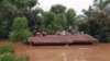 FILE - Villagers take refuge on a rooftop above flood waters from a collapsed dam in the Attapeu district of southeastern Laos, July 24, 2018.