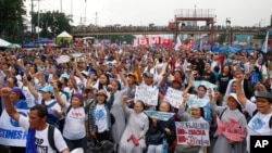 FILE - Protesters march toward the Philippine Congress to protest the State of the Nation address by President Rodrigo Duterte, July 22, 2019, in Quezon city, Philippines. Duterte was criticized for the thousands of killings in his war on drugs.