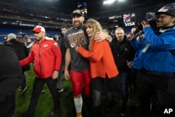 FILE - Kansas City Chiefs tight end Travis Kelce walks with Taylor Swift following the AFC Championship NFL football game between the Baltimore Ravens and the Kansas City Chiefs in Baltimore on Jan. 28, 2024. (AP Photo/Julio Cortez, File)
