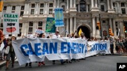 FILE - Climate change activists march during a protest in downtown Philadelphia ahead of the Democratic National Convention, July 24, 2016.