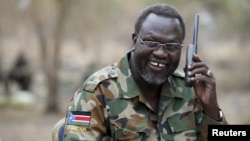 FILE - South Sudan's rebel leader Riek Machar talks on the phone in his field office in a rebel-controlled territory in Jonglei State, South Sudan, Feb. 1, 2014. 