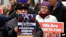 Wilfredo Mendoza of Boston, left, and Christina Villafranca of Malden, Mass., display placards during a rally called "We Will Persist" in Boston, Feb. 21, 2017. According to organizers, the rally was held to send a message to Republicans in Congress and the administration of President Donald Trump that they will continue to press for immigration rights and continued affordable health care coverage.