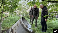 In this photo provided by the Odesa Regional Administration, city officials examine a fragment of a missile after the Russian missile attack that killed several people, and wounded multiple others in Odessa, Ukraine, April 29, 2024. 