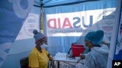 FILE - Nurse Nomautanda Siduna talks to a patient who is HIV-positive inside a gazebo used as a mobile clinic in Ngodwana, South Africa, July 2, 2020. 