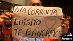 Uruguay fan shows a sign in solidarity with player Luis Suarez while waiting for his arrival outside Montevideo's Carrasco international airport, June 26, 2014.