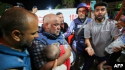 Al-Jazeera correspondent Wael Al-Dahdouh mourns over the body of one of his three children who were killed along with his wife in an Israeli strike in the Nuseirat camp, at Al-Aqsa hospital in Deir Al-Balah on the southern Gaza Strip, on Oct. 25, 2023. 