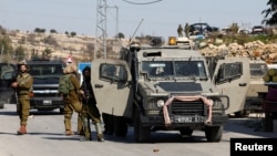 FILE - Israeli troops stand guard at the scene of a security incident near Hebron, in the Israeli-occupied West Bank, Jan. 17, 2023.