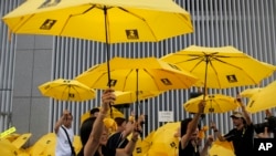 FILE - Protesters raise yellow umbrellas during a rally to mark the one year anniversary of "Umbrella Movement" outside the government headquarters in Hong Kong, Sept. 28, 2015.