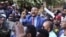 FILE - Jawar Mohammed, center, a member of the Oromo ethnic group who has been a public critic of Ethiopian Prime Minister Abiy Ahmed, addresses supporters outside his home in Addis Ababa, Oct. 24, 2019.