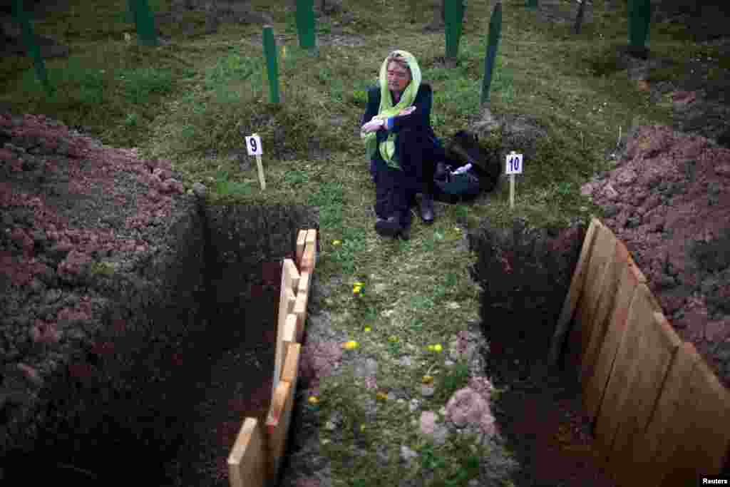 Rabija Dzodjaljevic duduk dan menangis dekat kuburan kerabatnya yang dimakamkan secara massal di kota Vlasenica, di wilayah Serbia.
