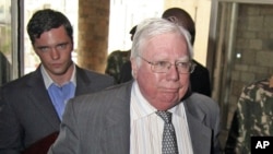 FILE - Jerome Corsi, right, arrives at the immigration department in Nairobi, Kenya, Oct. 7, 2008. Special counsel Robert Mueller's team believes Corsi tipped off a Donald Trump ally months before the release of emails stolen from Hillary Clinton's campaign chairman.