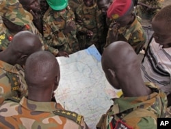 FILE - Soldiers from the Sudan People's Liberation Army (SPLA) examine a map in Pana Kuach, Unity State, South Sudan.