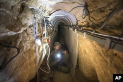 FILE - An Israeli army officer shows journalists a tunnel allegedly used by Palestinian militants for cross-border attacks from Gaza into Israel, July 25, 2014.