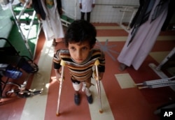 FILE - A young boy who lost his leg in the Yemen war uses a prosthetic limb at a government-run rehabilitation center in Sanaa, Yemen on March 5, 2016.