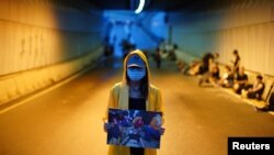 A protester holds a picture of an injured demonstrator, during a demonstration demanding Hong Kong's leaders to step down and withdraw the extradition bill, in Hong Kong, China, June 17, 2019.