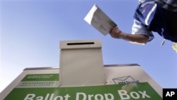 A voter drops off his ballot at a King County Elections drop box outside of a north Seattle public library, 02 Nov 2010