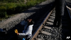 Seorang migran asal Venezuela tampak menunggu di rel kereta api dengan harapan dapat menaiki kereta barang yang akan bergerak menuju Huehuetoca, Meksiko, pada 20 September 2023. (Foto: AP/Eduardo Verdugo)