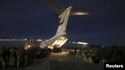 FILE - Russian marines, who guarded Russia's Hmeymim air base in Syria, are seen next to a plane at Belbek military airport near the Black Sea port of Sevastopol, in Russia-annexed Crimea, Dec. 28, 2015.
