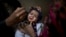 A Pakistani health worker, right, gives a polio vaccine to a child held by her mother at their home in Rawalpindi, Jan. 20, 2014.