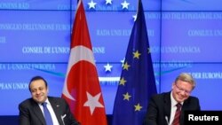 FILE-Turkey's European Affairs Minister Egemen Bagis (L) and European Enlargement Commissioner Stefan Fuele after EU-Turkey accession talks, Brussels, Nov. 5, 2013.