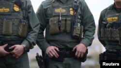 U.S. Border Patrol agents watch as President Donald Trump visits the banks of the Rio Grande River in Mission, Texas, Jan. 10, 2019. 
