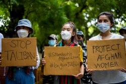 Young Afghan women exiled in India take part in an anti-Taliban demonstration in New Delhi on August 23, 2021.