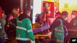 Los paramédicos llevan a una ambulancia a uno de los cuatro hermanos indígenas que estaban desaparecidos después de un accidente aéreo, en la base aérea militar de Bogotá, Colombia, el sábado 10 de junio de 2023. (Foto AP/John Vizcaíno)