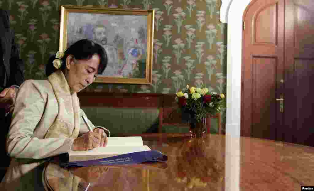 Aung San Suu Kyi signs a book at the Nobel Institute after a meeting with the Norwegian Nobel Committee in Oslo, June 16, 2012.