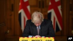 Britain's Prime Minister Boris Johnson reacts while leading a virtual press conference on the Covid-19 pandemic, inside 10 Downing Street Jan. 26, 2021, as official data shows that more than 100,000 people have died since the pandemic took hold last year.