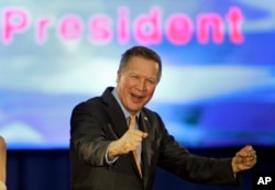 FILE - Republican presidential candidate Ohio Gov. John Kasich pumps his fist and celebrates before speaking at his presidential primary election rally in Berea, Ohio, March 15, 2016.