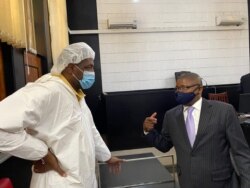 Hopewell Chin'ono talking to Harrison Nkomo of Zimbabwe Lawyers for Human Rights in the courthouse at Harare Magistrate’s Court (Photo: Columbus Mavhunga/VOA)
