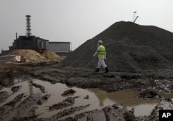 FILE - A plant worker walks by construction site in Chernobyl, (VOA - D. Markosian, April 2011)