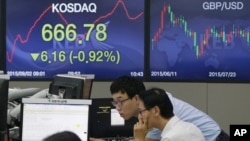 Currency traders work at the foreign exchange dealing room of the KEB Hana Bank headquarters in Seoul, South Korea, Wednesday, Sept. 2, 2015. 