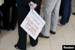 An audience member holds a hand lettered sign calling for further gun control at a campaign stop with U.S. Democratic presidential candidate Hillary Clinton in Nashua, New Hampshire Oct. 16, 2015.