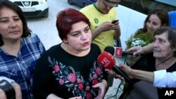 Azeri Khadija Ismayilova, center, a reporter for Radio Free Europe/Radio Liberty, who became a symbol of defiance, praised by human rights and free-speech groups, speaks to journalists after she was released in Baku, Azerbaijan, May 25, 2016.