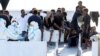 FILE - Migrants wait to disembark from the Italian coast guard vessel "Diciotti" at the port of Catania, Italy, Aug. 22, 2018.