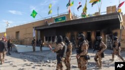 Iraqi army soldiers are deployed in front of the U.S. embassy in Baghdad, Iraq, Jan. 1, 2020, after Iranian-backed protesters withdrew from the compound.